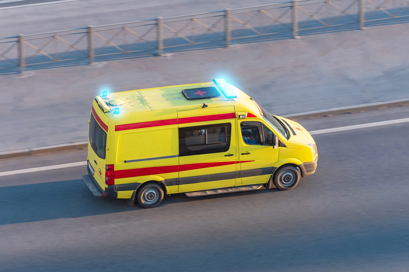 Ambulance avec les girophares allumés se rendant roulant sur une chaussée